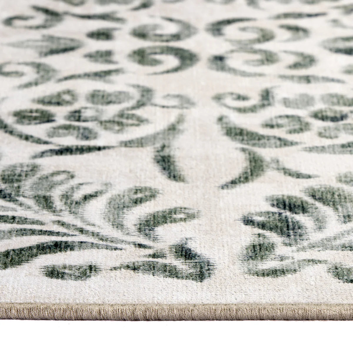 Close-up of a patterned rug with green and beige design