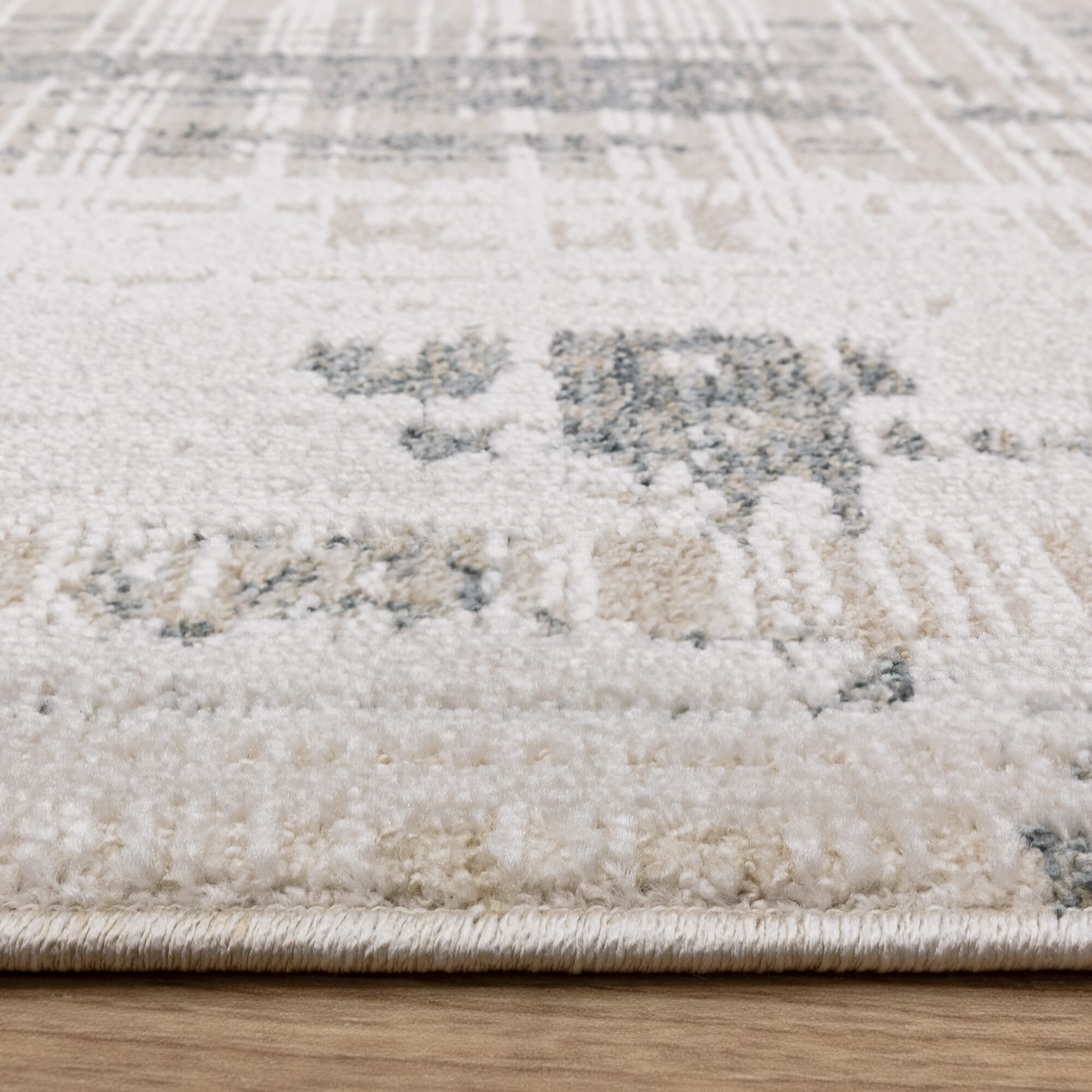 Neutral patterned rug on wooden flooring

