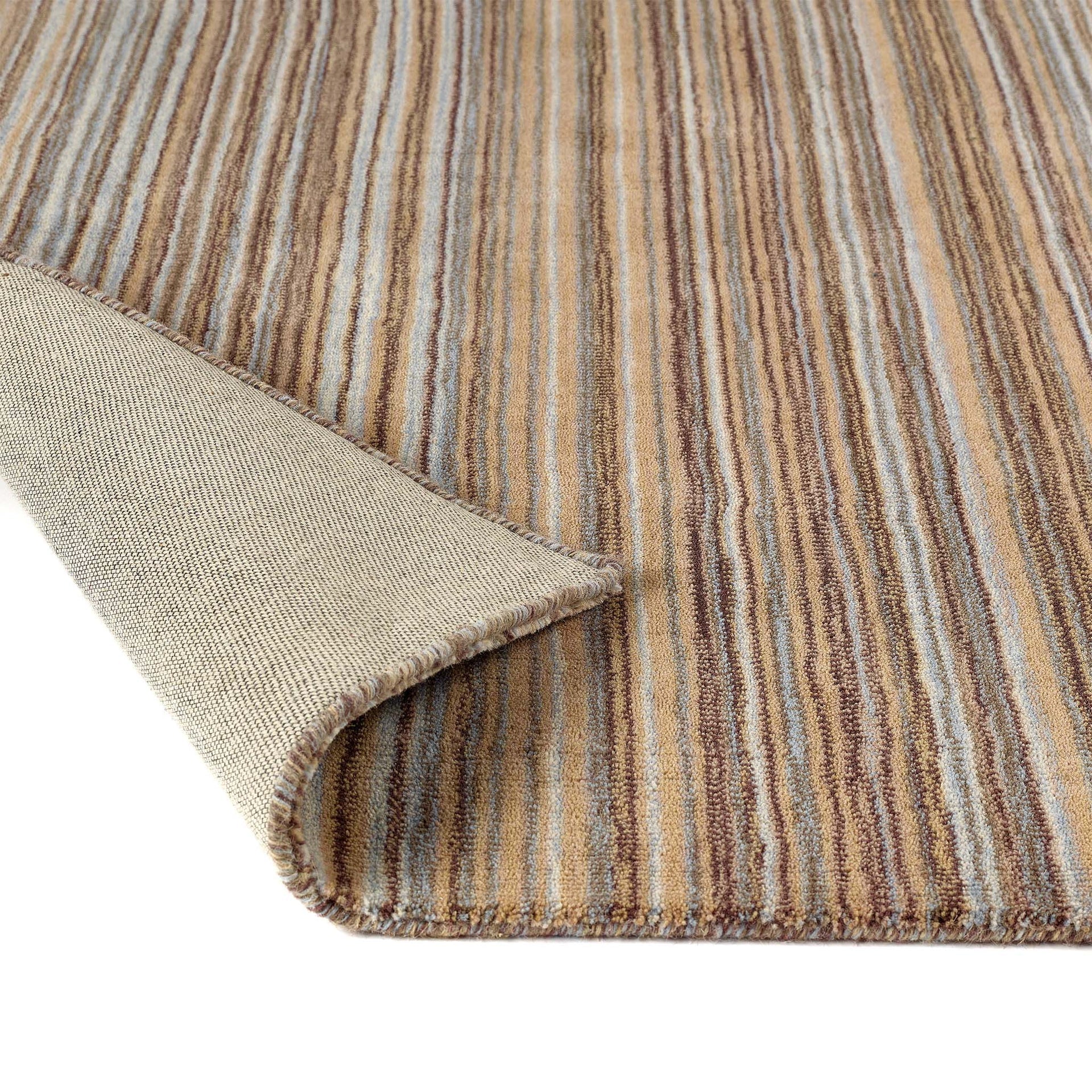 Close-up of a striped rug with brown, beige, and blue colors.