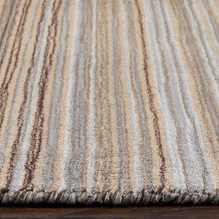 Close-up of a textured rug with horizontal stripes in brown, beige, and gray.