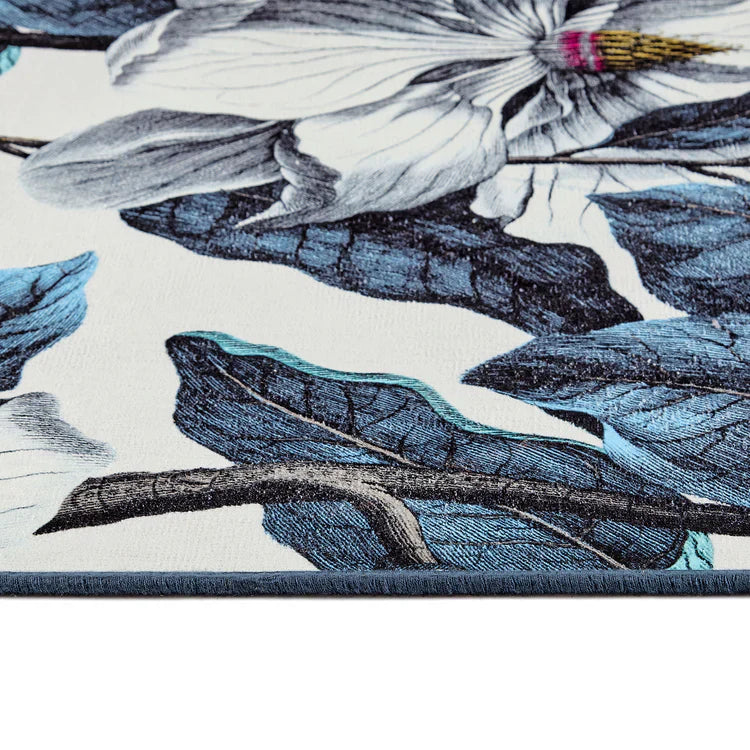 Close-up of a floral pattern with blue leaves and white flowers on a beige background