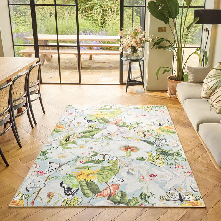 Decorative rug with nature-themed design on a wooden floor in a living room.