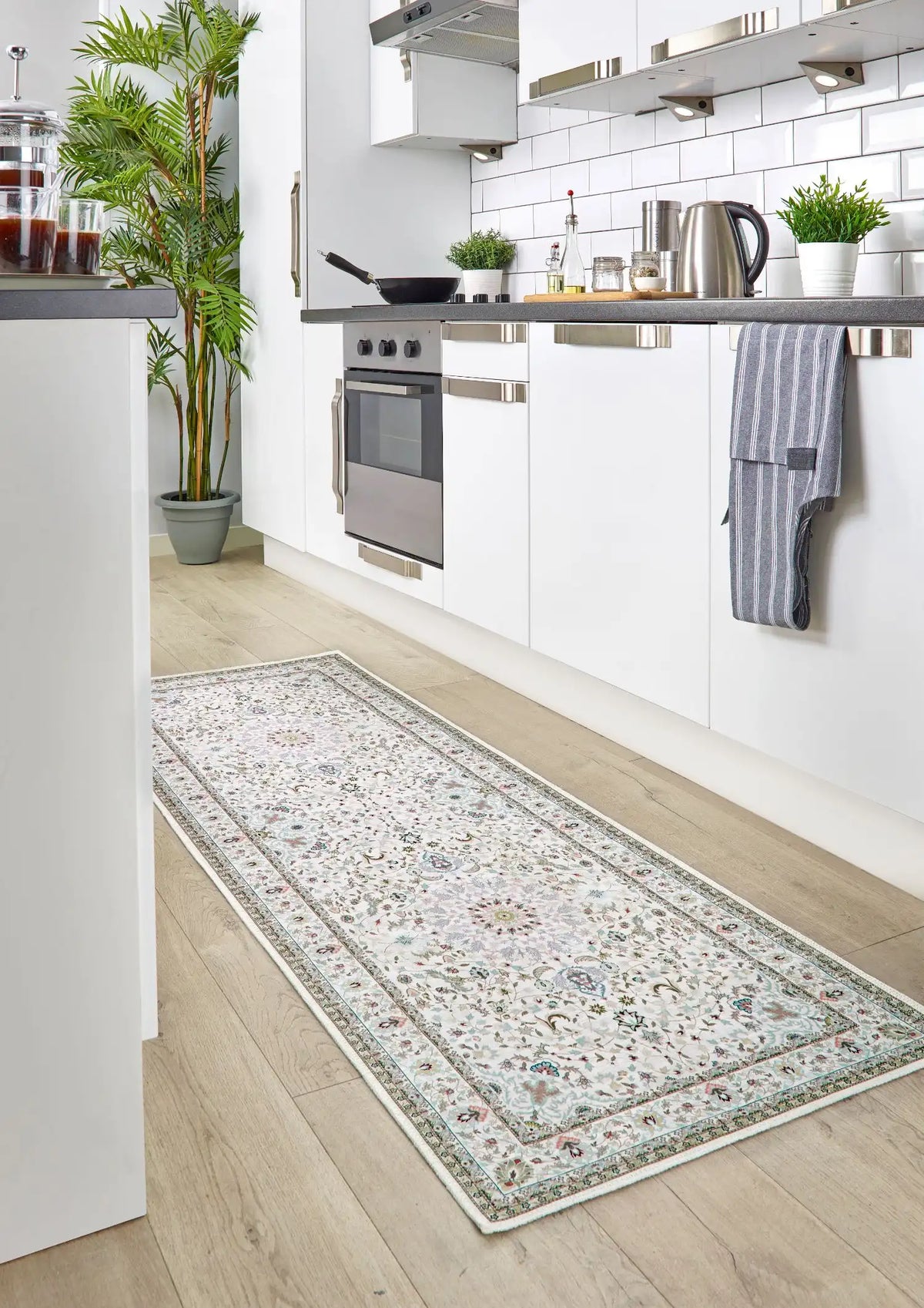Long rectangular rug with floral pattern on a wooden floor in a kitchen.