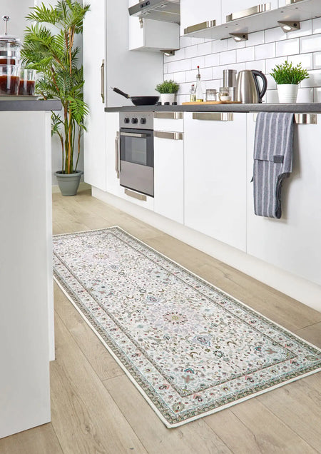 Long rectangular rug with floral pattern on a wooden floor in a kitchen.