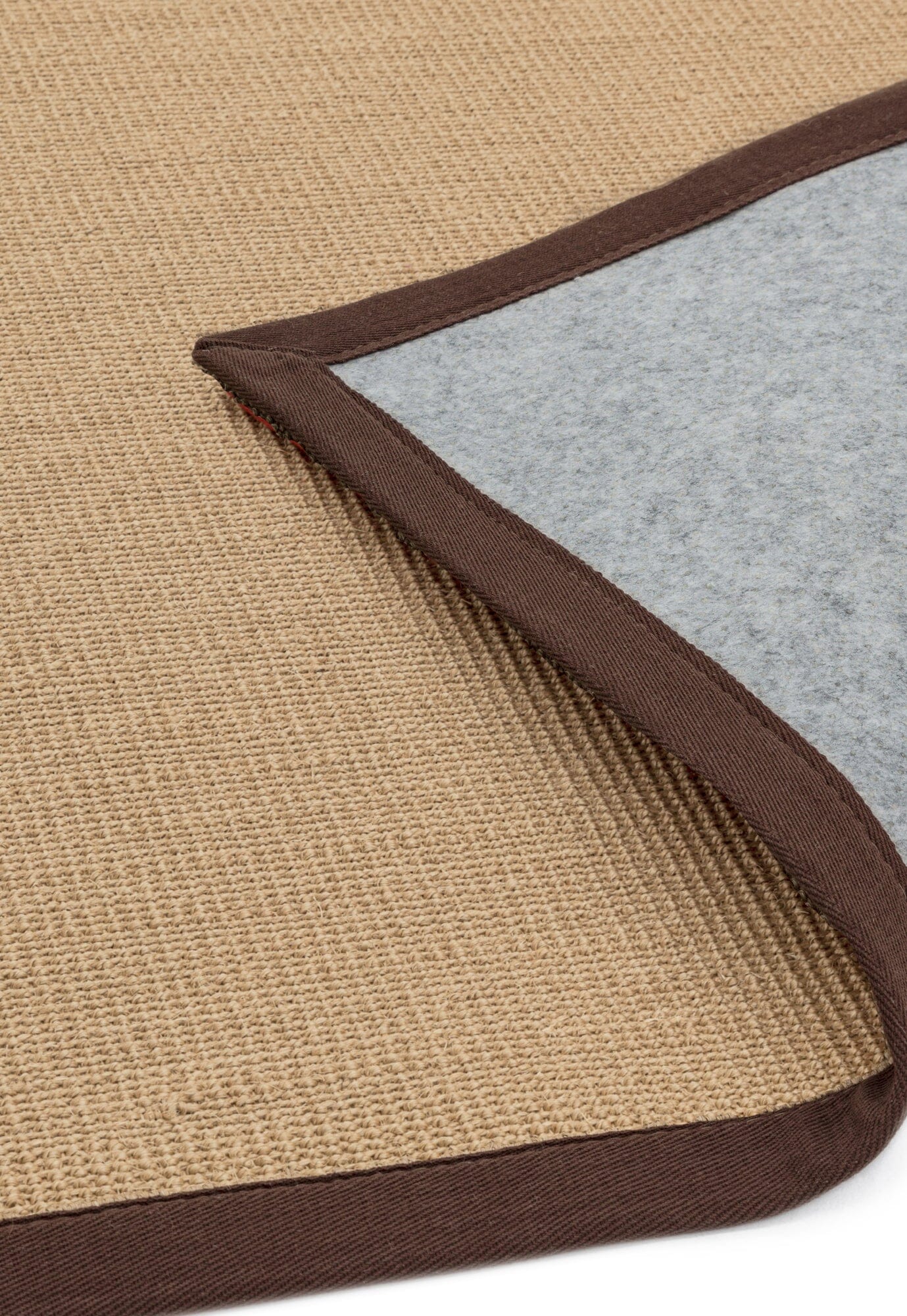 Low pile sisal rug with warm-toned edge showing non slip backing