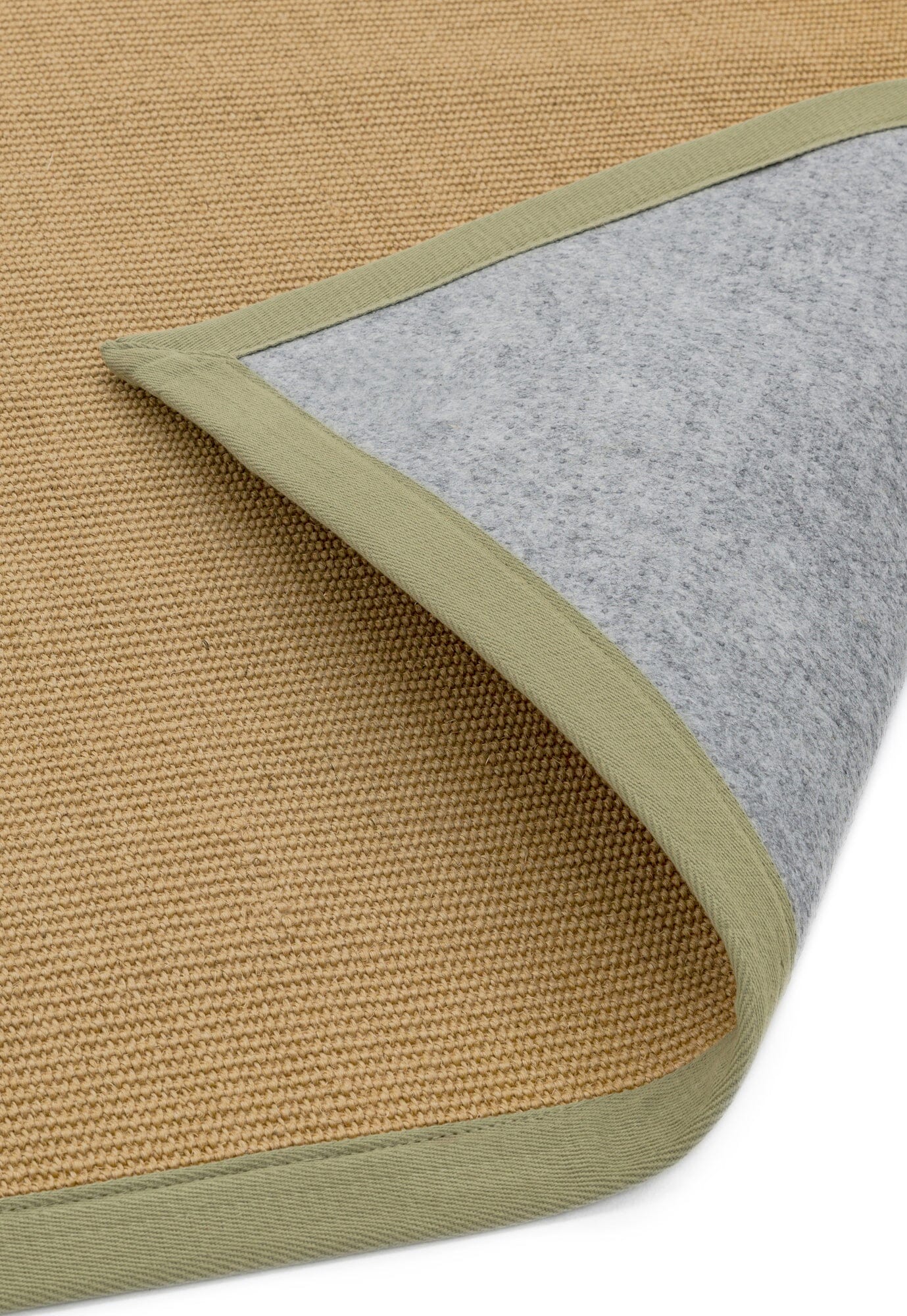 Hand-stitched sage border on neutral rug showing non slip backing